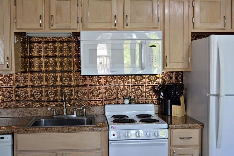Kitchen with full size fridge, dishwasher, and microwave. 