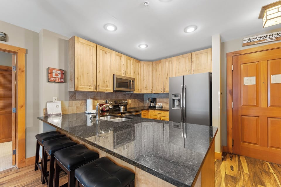 Your fully equipped kitchen features granite counters, stainless steel appliances, and breakfast bar seating for memorable meals together.