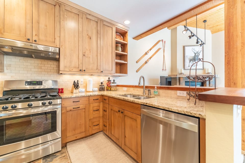 Full size kitchen with granite countertops and stainless steel appliances.