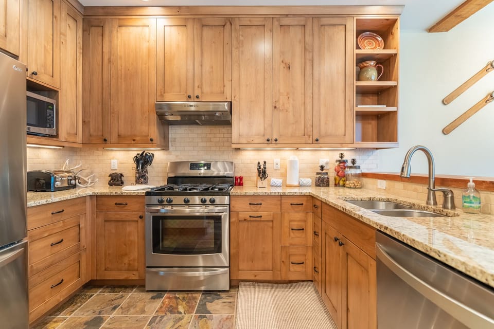 Full size kitchen with granite countertops and stainless steel appliances.