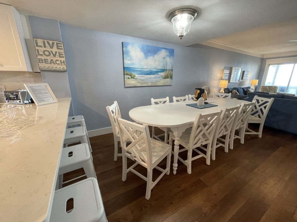 2nd floor dining table with 10 chairs and 4 bar stools at kitchen bar