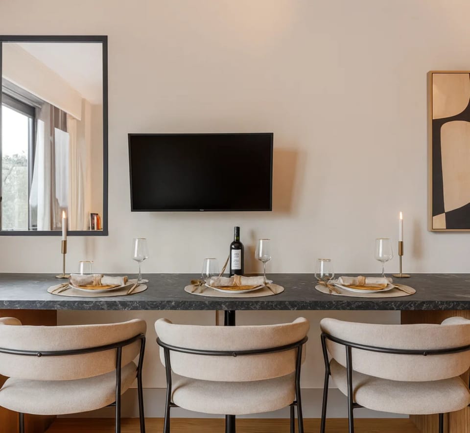 A dining table in the living room up to the TV.
