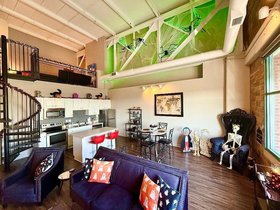 Loft Living Room & Kitchen
Spooky elegance with towering cobwebs, glowing lights, and festive accents. Skeleton royalty and ghostly pillows set the perfect Halloween mood.
