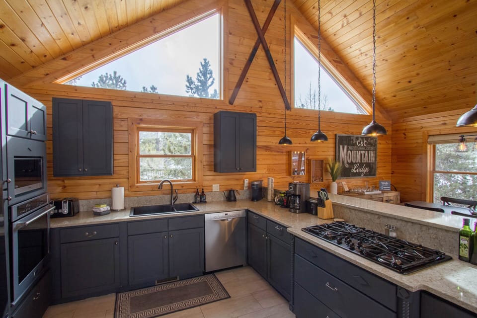 Large Kitchen with gas cooktop, toaster, blender, microwave, oven, blender.