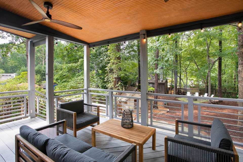 Covered back porch with seating and grill, perfect for winding down.