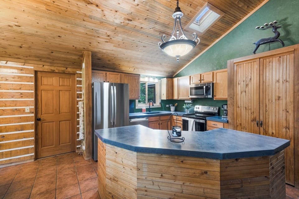 Fully equipped kitchen stainless steel appliances and concrete countertops.