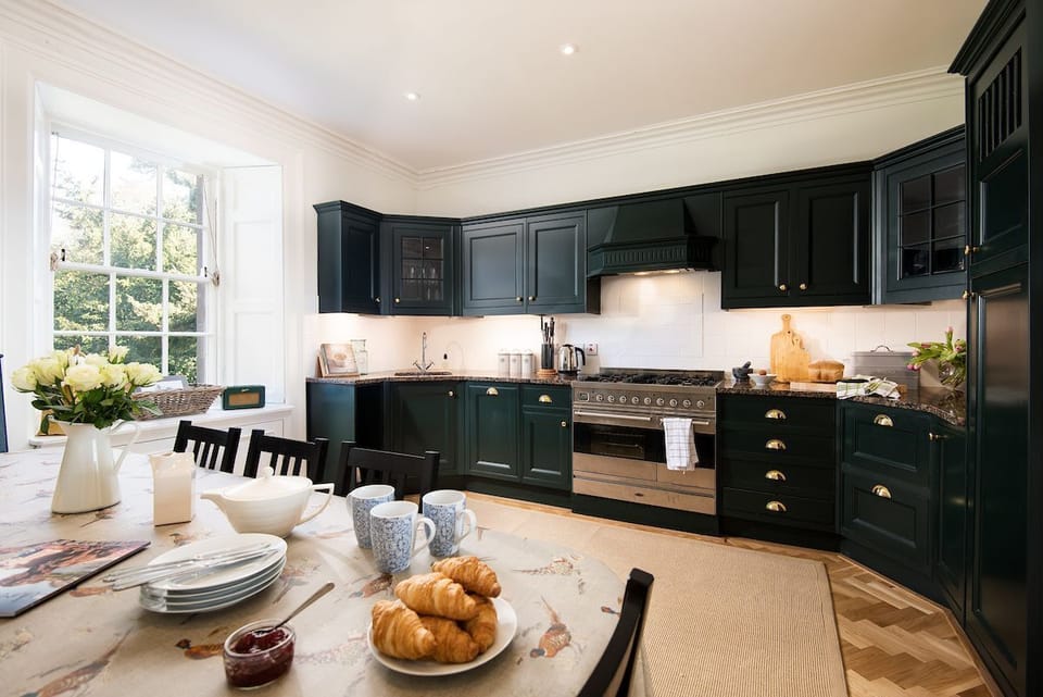 Cairnbank House - the kitchen with painted cabinets in Farrow & Ball studio green is an informal space for breakfasts and lunches