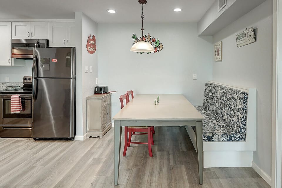 Your modern kitchen flows into a cozy dining nook where morning coffee and evening meals become memorable moments together.