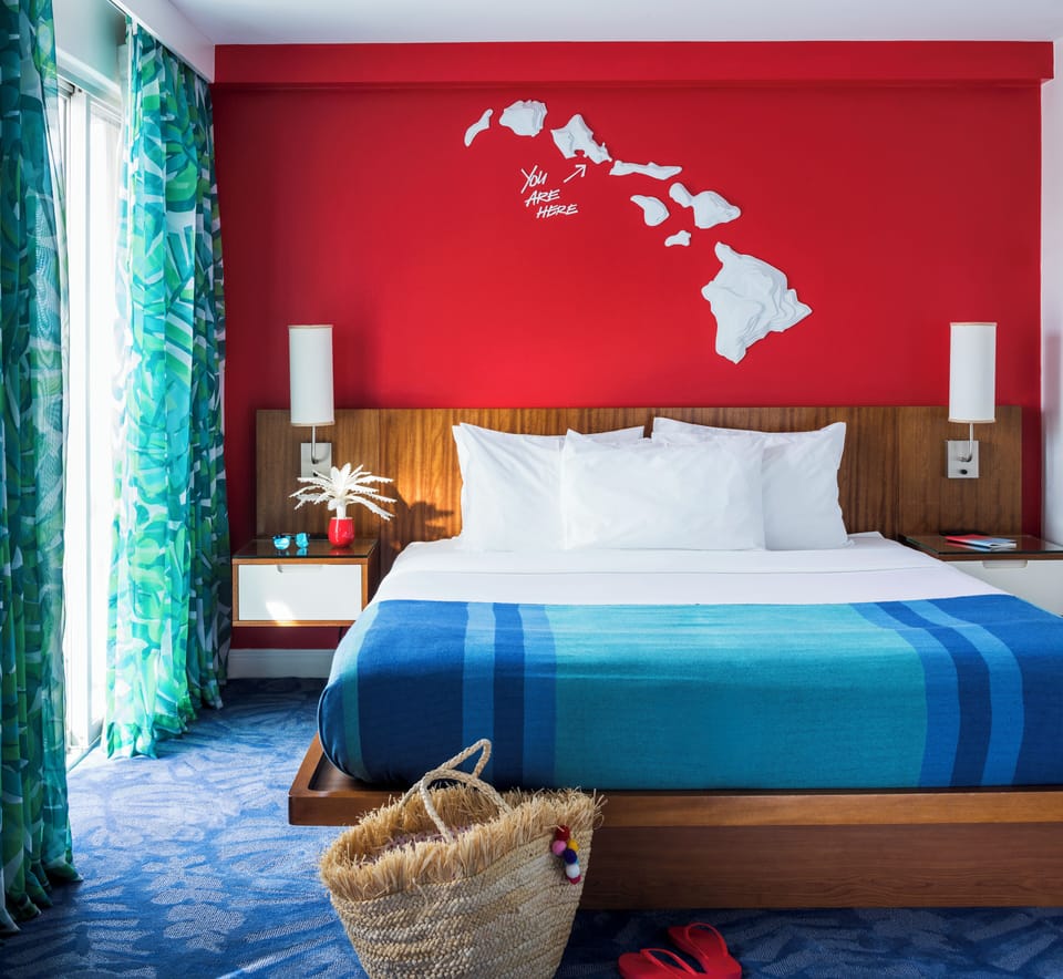 Stretch out on a plush king bed under bold island art.