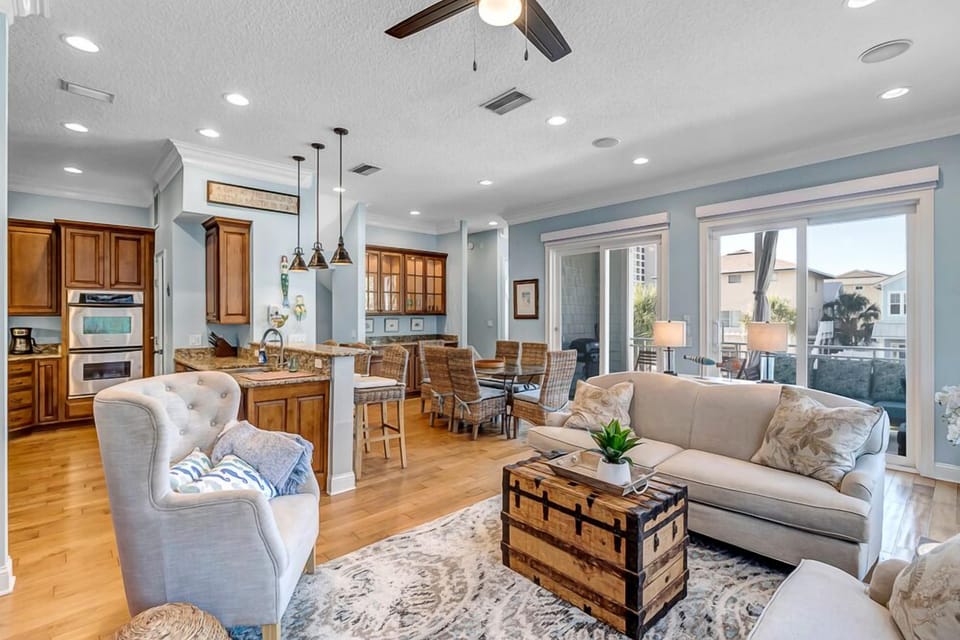 Main Living and Entertaining Area - - Spacious open floor plan connecting kitchen, dining, and living areas
- Coastal tones, plush seating, and outdoor access make the space welcoming and functional
- Ideal for entertaining or enjoying quiet family moments