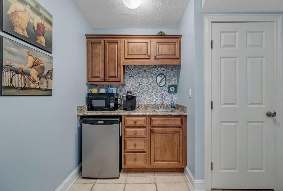 Ground Floor Kitchenette - - Convenient coffee nook with microwave, Keurig, mini fridge, and granite counter
- Vibrant backsplash adds charm while upper and lower cabinets offer storage
- Perfect for quick breakfasts or a late night snack station