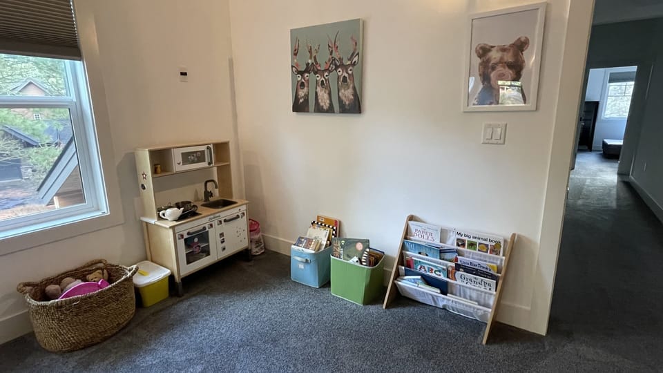 Kids’ corner in the bonus room with play kitchen, toys, and books