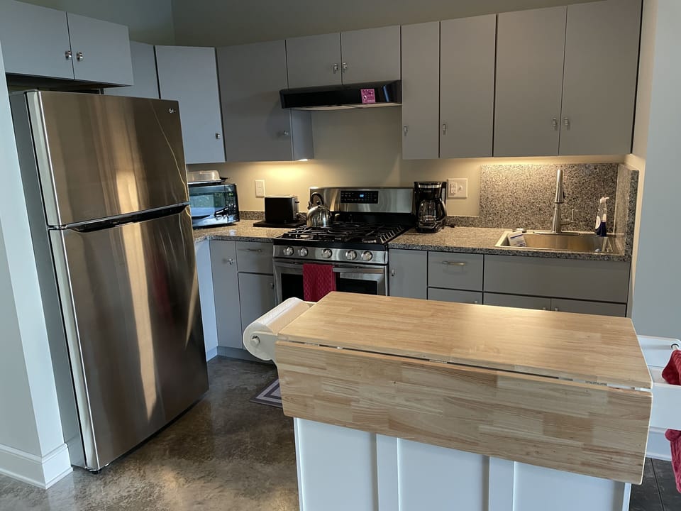Kitchen with stove, refrigerator, microwaver.