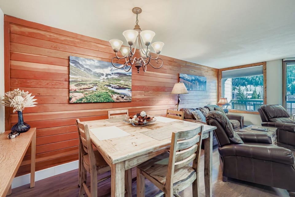 Relax in your cozy living and dining area featuring warm wood accents, comfortable leather seating, and rustic dining table perfect for memorable meals.