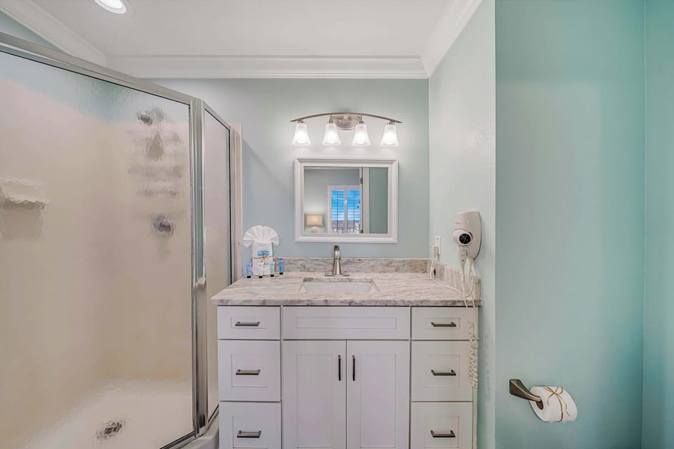 This ensuite bathroom also features granite countertops and has a walk-in shower.