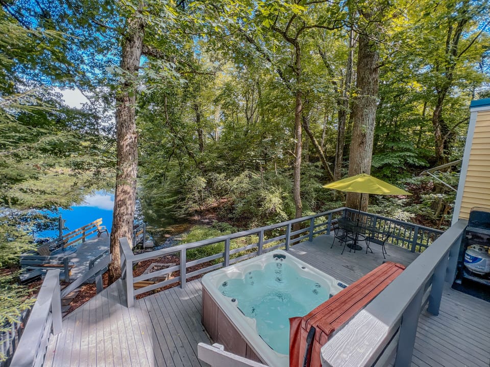 View from the back deck overlooking the hot tub, patio set, and fire pit. 