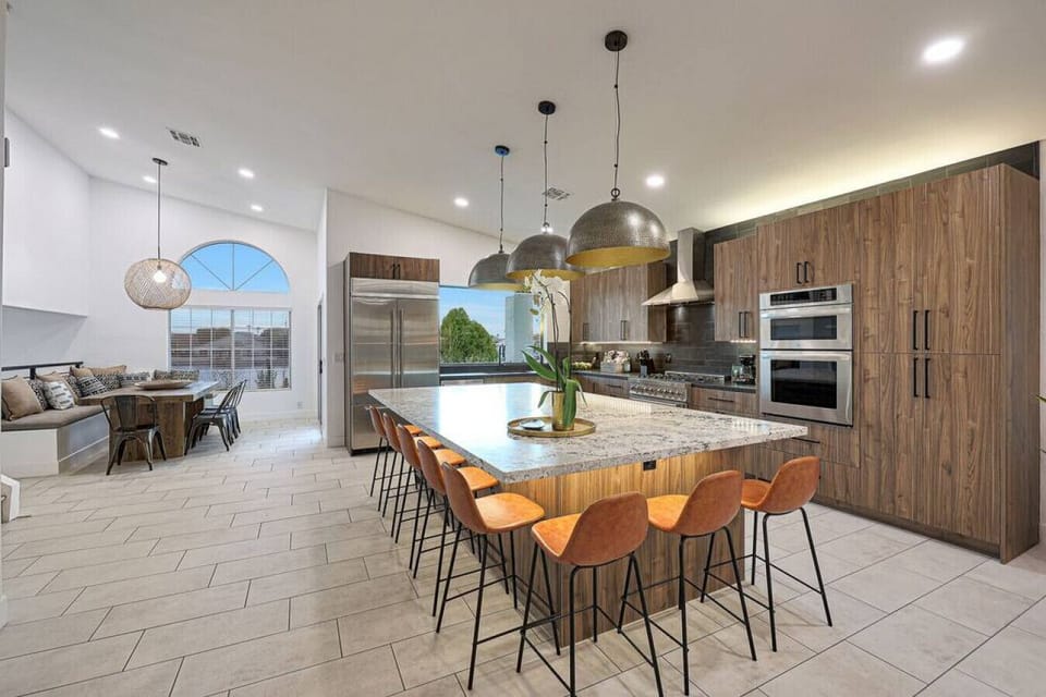 Prepare meals in style in this chef`s kitchen, featuring a massive quartz island with seating for six and premium stainless steel appliances.