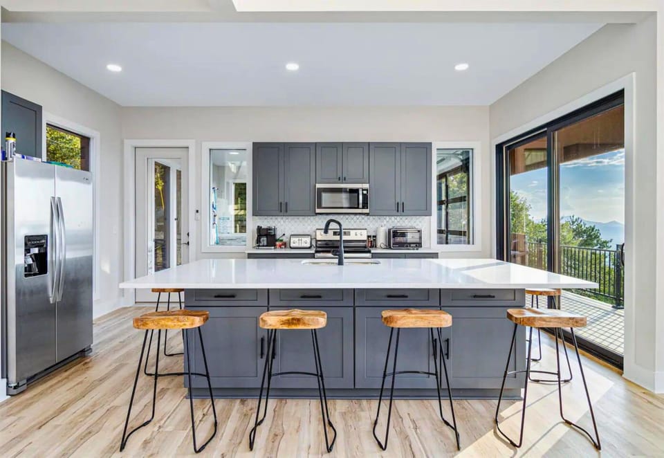 A modern seating arrangement surrounds the spacious kitchen island, ideal for casual dining or quick snacks.
