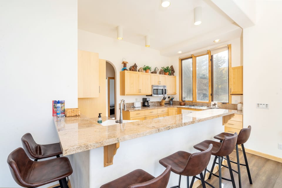Open kitchen with breakfast bar seating for six