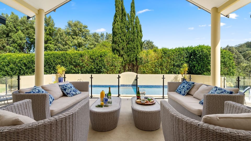 outdoor dining and entertainment area of south coast accommodation overlooking a pool
