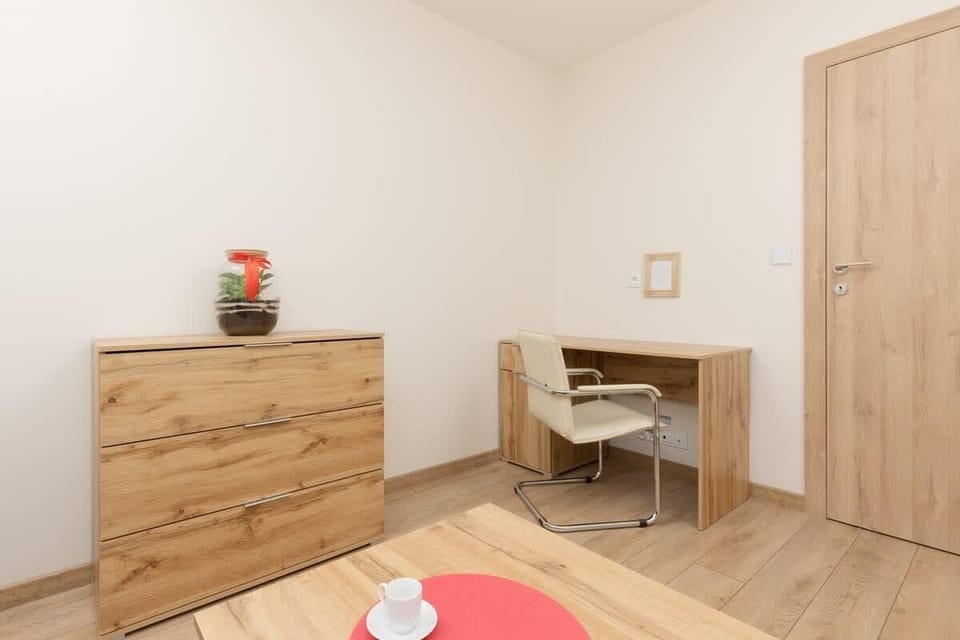 A small workspace in the bedroom with a wooden desk and drawers, perfect for working or studying.
