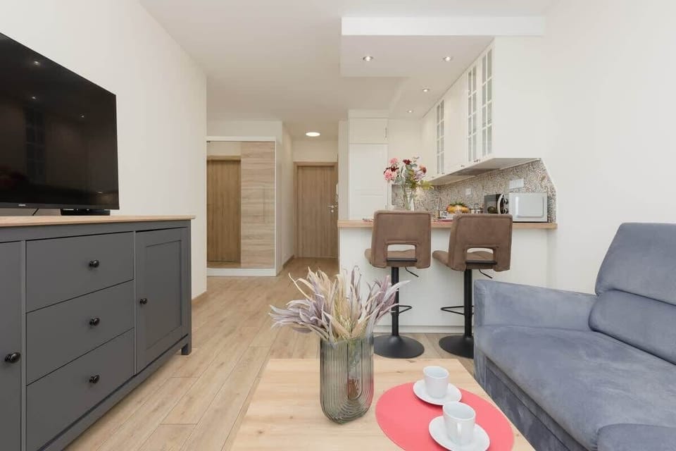 A wide shot of the living and dining area, with neutral tones and modern decor.
