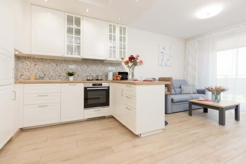 A different angle of the kitchen, showcasing the dining area and built-in appliances, creating a practical and stylish space.
