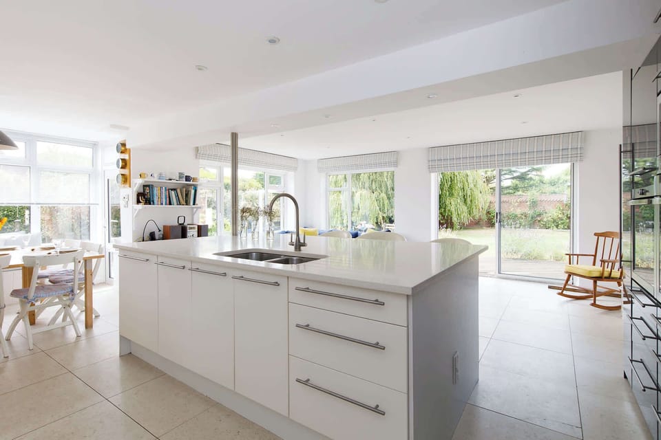 The open plan kitchen features a huge island complete with breakfast bar and four stools.