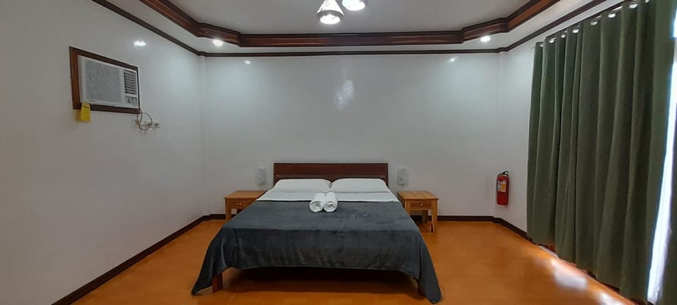 King size bed with blackout curtains drawn closed.