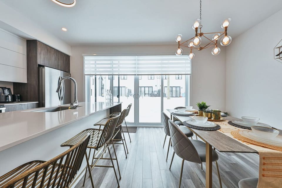 Bright kitchen and dining nook with quartz countertops, stainless steel appliances, and direct access to the balcony.