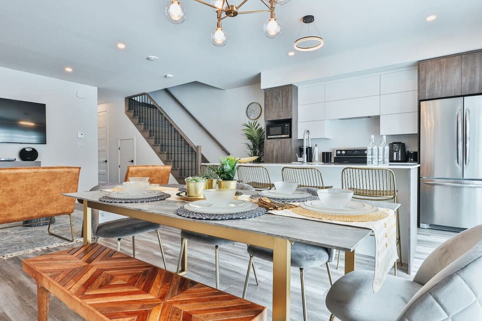 Elegant dining area with seating for eight, set beneath a striking chandelier and steps from the kitchen.