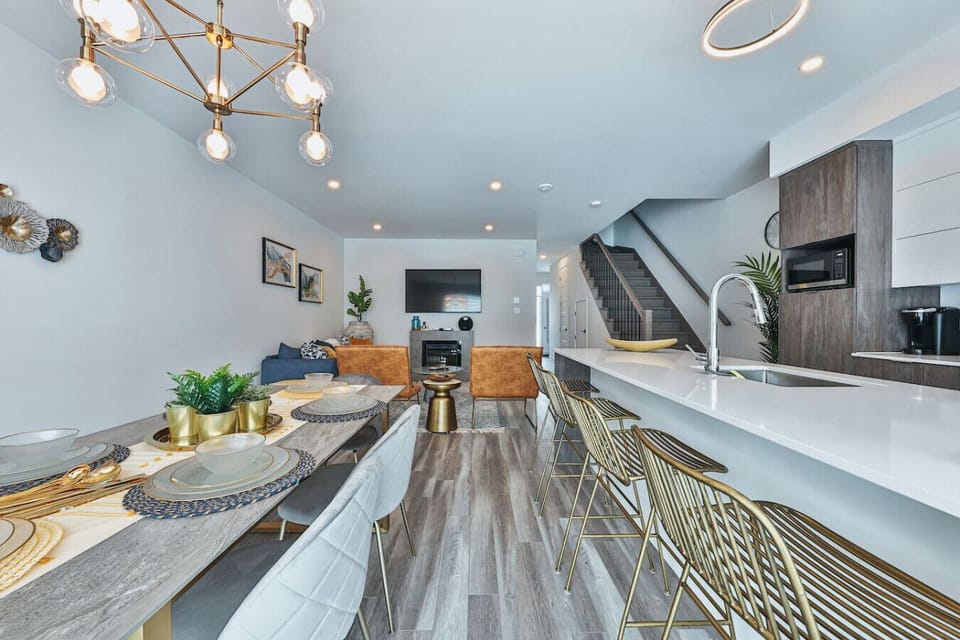 Sweeping view of the open-concept main floor, from dining area to kitchen island with bar seating.