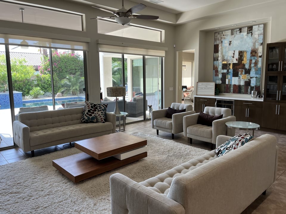 Spacious living room with large smart TV, contemporary furnishings, and bar area