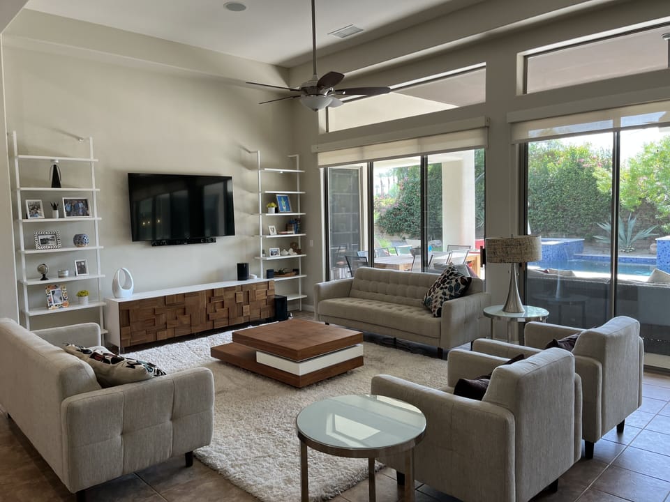 Spacious living room with large smart TV, contemporary furnishings, and bar area