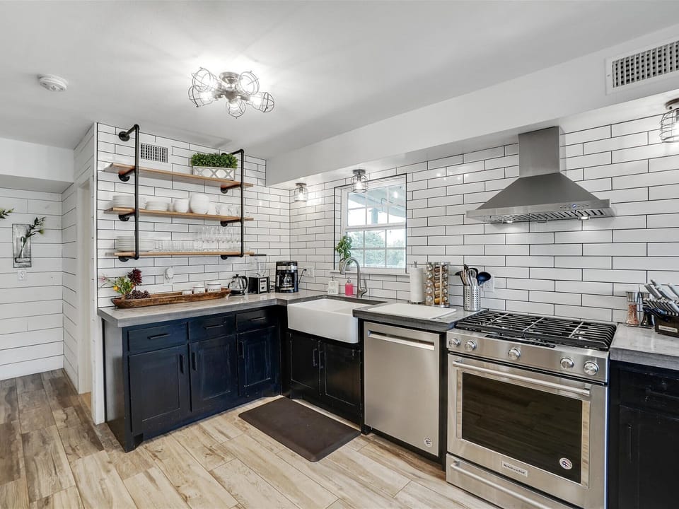 Equipped with classic white subway tiles and open shelving for an authentic rustic atmosphere, this open-concept kitchen makes it easy to whip up a southern meal!