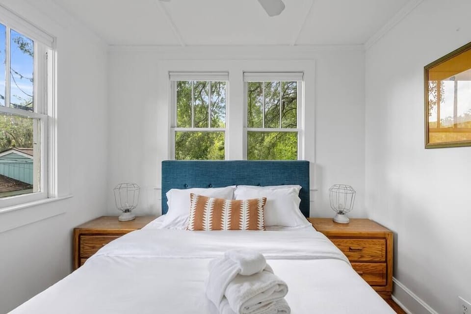 The bedroom has a queen-sized platform bed, all cotton linens, and tree top views.