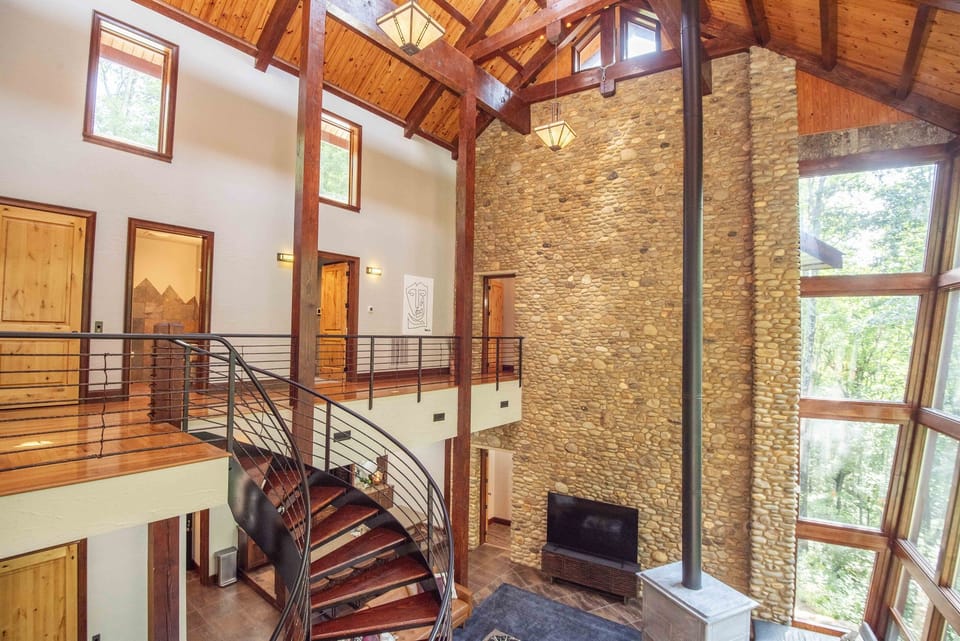 A grand living room featuring soaring ceilings and the eye-catching spiral staircase.