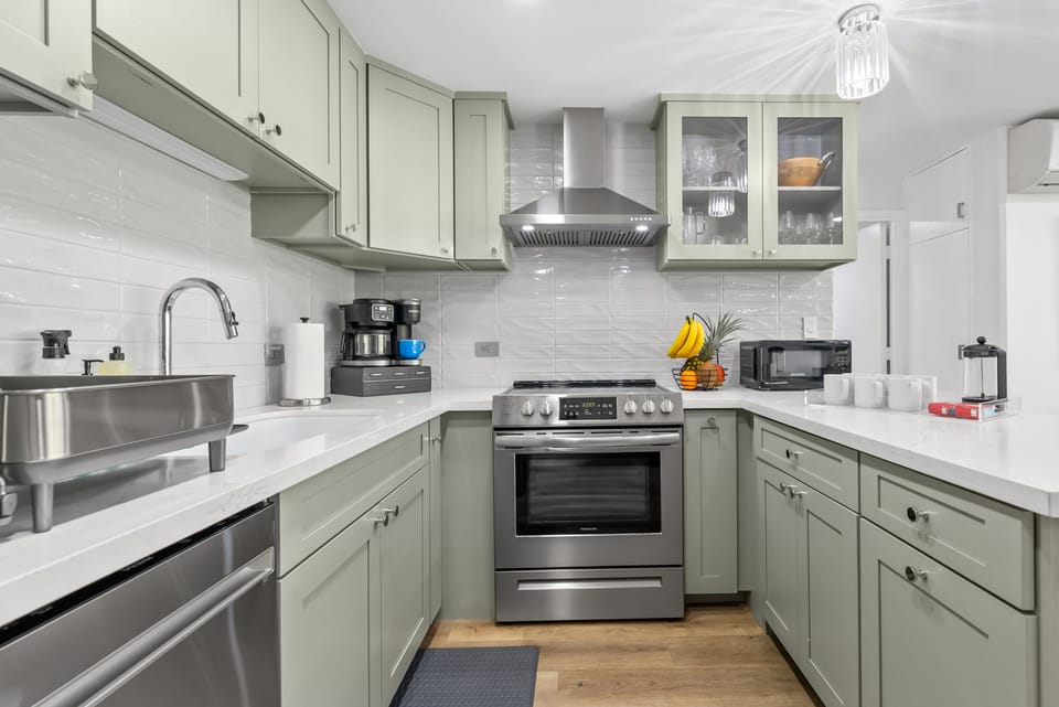 Fully-equipped kitchen with stainless steel appliances & cookware.