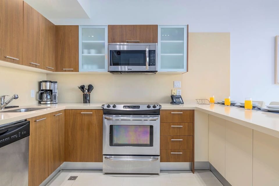 Your sleek modern kitchen features stainless steel appliances and warm wood cabinetry, creating the perfect space for preparing memorable meals.