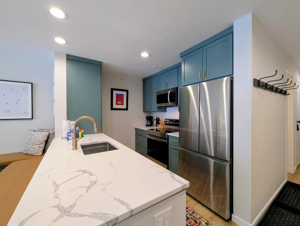 Your stylish kitchen features teal cabinets, marble countertops, and stainless steel appliances for memorable meal prep.