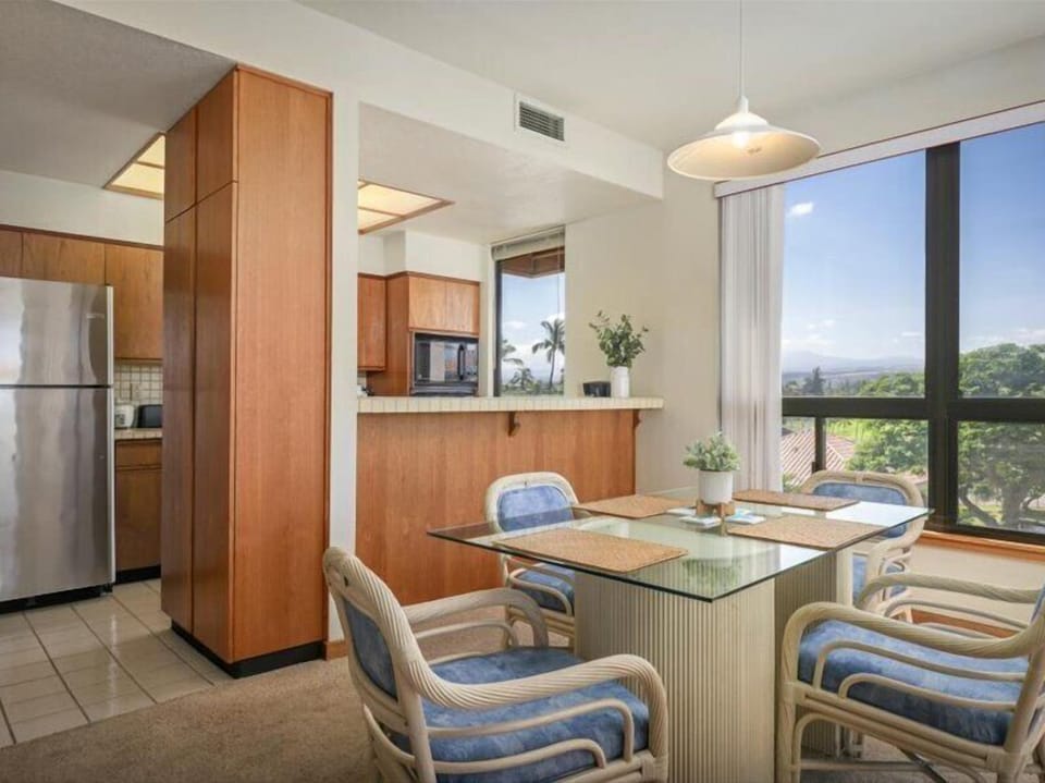 Gather around your sunny kitchen island with mountain and garden views—warm wood, modern amenities, and natural light make every meal feel special in your Hawaiian retreat.