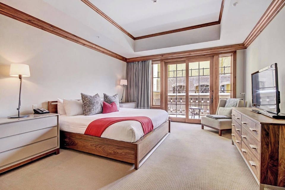 The primary bedroom features a king bed, TV, and ensuite bathroom.