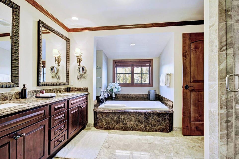 The primary bathroom boasts dual vanities, heated floors, a jetted tub, and a walk-in shower.