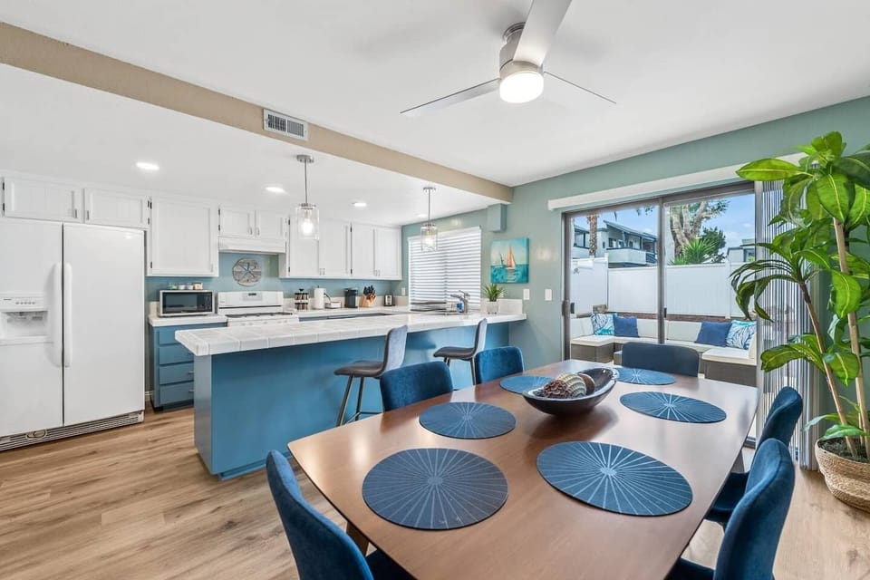 Spacious dining room with a very large dining table and an oversized island bar. 