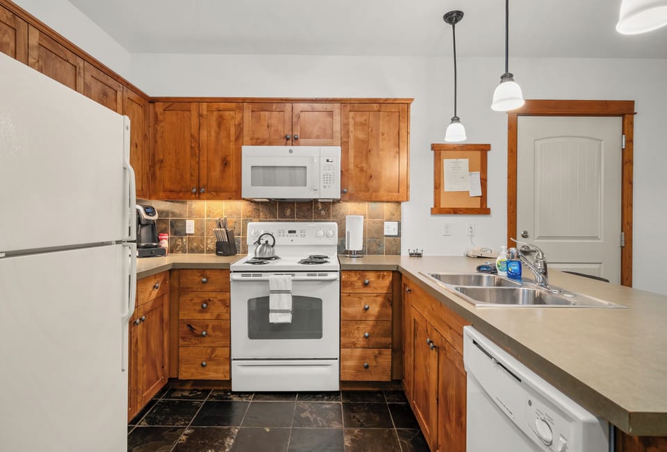 Warm, fully equipped kitchen with wood cabinetry and spacious counters