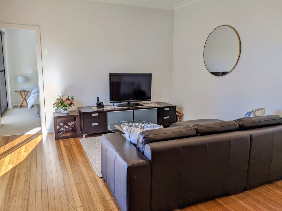 Lounge room with L shaped leather sofa and glass coffee table