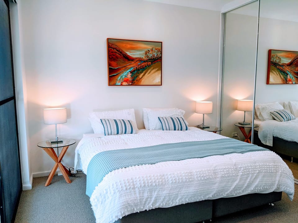 Bedroom with king bed and large mirrored wardrobes