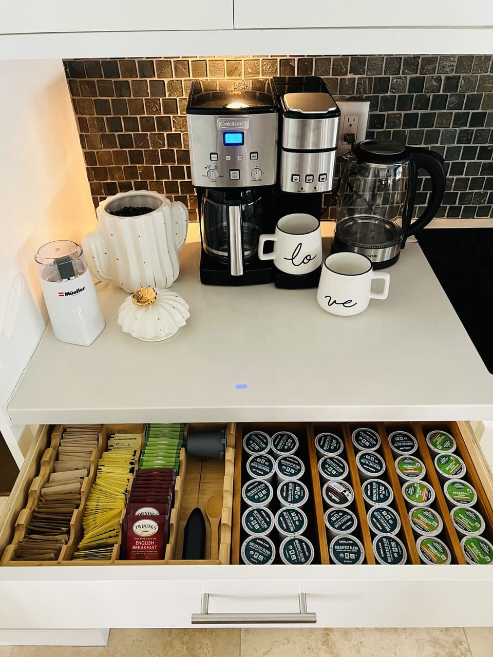 Coffee station with pods, beans, sugar, sweetener, tea, grinder, water kettle.