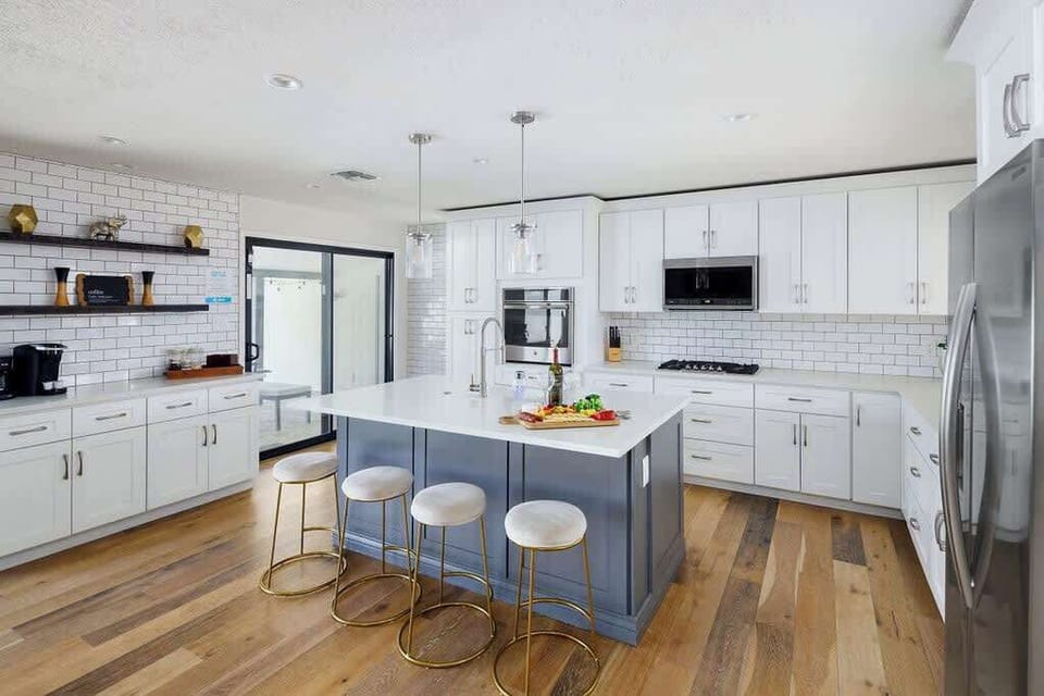 Fully equipped kitchen with stainless steel appliances, coffee bar, breakfast bar seating, and filled with basic cooking essentials.
