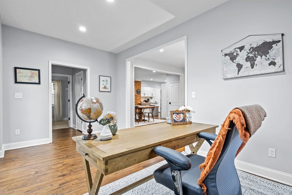 Stylish, thoughtfully designed office area featuring a large desk, cozy seating, and inspiring décor.